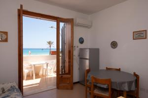 a dining room with a table and a view of the beach at Appartamento Coryna sul Mare in San Vito lo Capo