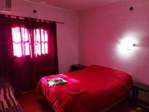 - une chambre avec un lit rouge et une fenêtre dans l'établissement Posada Chaupihuasi, à Villa Unión