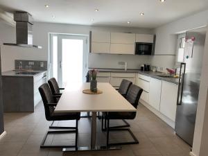 a kitchen with a table and chairs and a refrigerator at FeWo Lina - Komfortwohnung mit Badewanne, Kamin & Klima in Kronau +10 photos