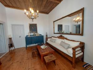 a living room with a couch and a mirror at La Belle House in Kalloni in Kalloni Tinou
