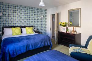 a blue and white bedroom with a bed and a chair at Dream Stays Bath - Trim Street (Hot tub) in Bath