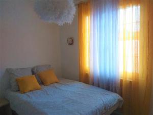 a bedroom with a bed with blue sheets and a window at MAISON de VACANCES in Seyresse +19 photos