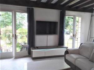 a living room with a couch and a flat screen tv at MAISON de VACANCES in Seyresse