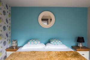 a blue bedroom with a bed with a blue wall at Dream Stays Bath - Queen Street Loft Apartment in Bath