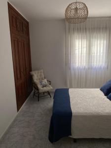 - une chambre avec un lit, une chaise et un lustre dans l'établissement El paraíso, à Raxo