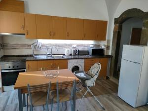 a kitchen with a table and a white refrigerator at A Lapa in Mourão