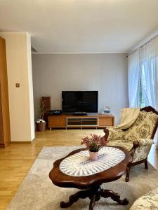 a living room with a tv and a coffee table at Apartament Mazurskie Ciepło in Mikołajki