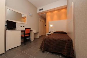 a bedroom with a bed and a desk and a table at Hotel Cavour in Rieti