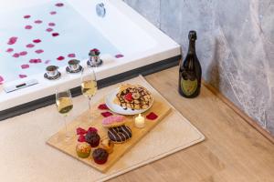 a table with a plate of food and two glasses of wine at Relax House & SPA - DISNEY in Crecy la Chapelle +16 photos