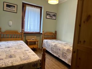 um quarto com 2 camas e uma janela em Residence Alpen Casavacanze em Pinzolo