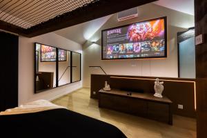 a bedroom with a flat screen tv on the wall at Relax House & SPA - DISNEY in Crecy la Chapelle