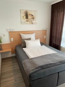 a bedroom with a large bed with a wooden headboard at Restaurant San Marco in Ammerndorf