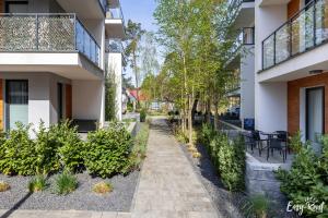 a walkway in the courtyard of a building with plants at Apartament BLUE 17 z basenem in Pobierowo