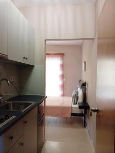a kitchen with a sink and a bed in a room at Horizon Blue in Loutsa