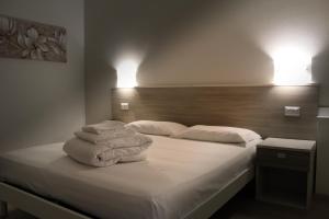 1 dormitorio con 1 cama con toallas en Hotel Roma, en Palmanova