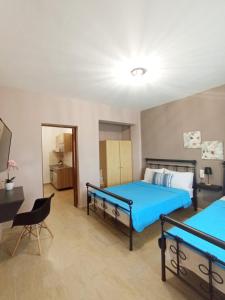 a bedroom with two beds and a desk and a chair at Horizon Blue in Loutsa