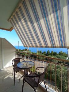 a patio with two chairs and a table on a balcony at Horizon Blue in Loutsa