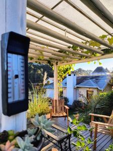 un patio con TV en una pérgola en Chalés Lanelli en Monte Verde