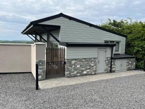 a garage with a black roof and a gate at Channel View in Weston-super-Mare