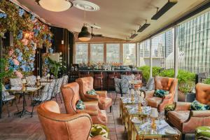 a restaurant with leather chairs and a bar at Le Meridien New York, Central Park by Marriott in New York