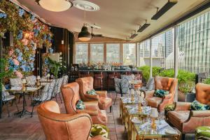 a restaurant with leather chairs and a bar at Le Meridien New York, Central Park in New York