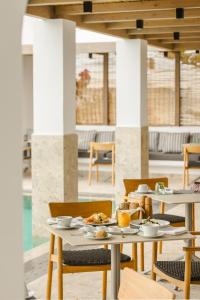 a table with plates of food on it in a restaurant at Grace Mykonos in Agios Stefanos