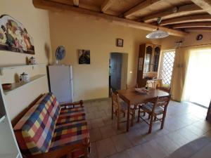 a kitchen and dining room with a table and chairs at CASA PRAIOLA Tangerine's House by the SEA in Pozzillo +11 photos