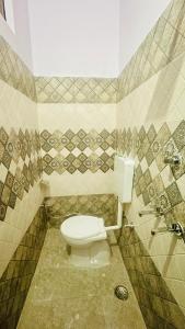 ein Bad mit einem weißen WC in einem Zimmer in der Unterkunft Tandon Lodge in Varanasi