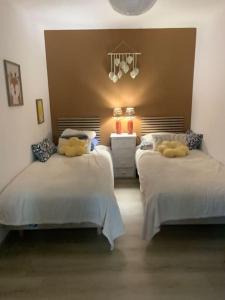 Saint-Pierre-lès-ElbeufにあるGîte du Levant 76のぬいぐるみが置かれたベッドが2つある寝室