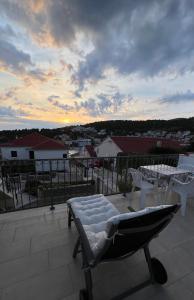 d'un balcon avec un lit et des tables sur le toit. dans l'établissement Forr Apartments - Hvar, Croatia, à Hvar