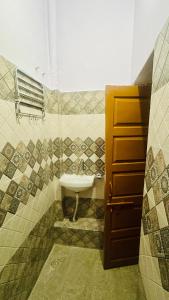 La salle de bains est pourvue d'un lavabo et d'un miroir. dans l'établissement Tandon Lodge, à Varanasi