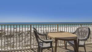 a table and chairs on a balcony overlooking the beach at Cabana Club 206 Gulf Oceanfront, King Bed, private beach in Destin