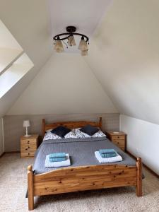sypialnia z drewnianym łóżkiem na poddaszu w obiekcie Apartament Mazurskie Ciepło w mieście Mikołajki