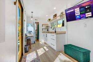 科罗拉多斯普林斯Cargo Casita Shipping Container Tiny Home的厨房配有白色橱柜和绿色凳子
