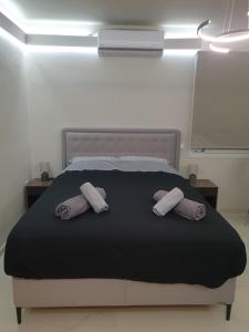 a bedroom with a bed with two towels on it at BlackGeorge Apartment in Ioannina