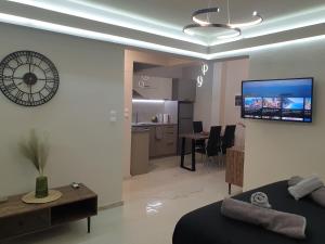 a living room with a couch and a tv on a wall at BlackGeorge Apartment in Ioannina