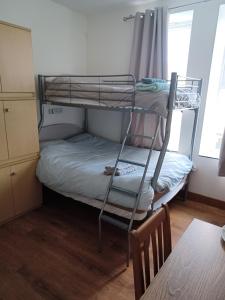 a room with two bunk beds and a table at Voyage Hostel - Ensuite Family Rooms with shared kitchen in Douglas