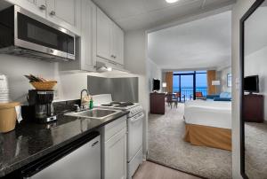 een keuken met een wastafel en een bed in een kamer bij Best Western Ocean Sands Beach Resort in Myrtle Beach