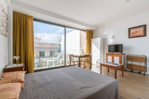 - une chambre avec un lit et une grande fenêtre dans l'établissement Loft moderno con balcón al lado de Las Canteras, à Las Palmas de Gran Canaria