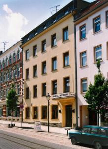 een groene auto geparkeerd voor een gebouw bij Hotel Merkur Garni in Zwickau