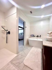 a white bathroom with a tub and a sink at The Savannah Suite in Winona