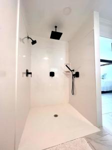 a white bathroom with a cross on the wall at The Savannah Suite in Winona +7 photos