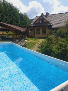 uma grande piscina azul em frente a uma casa em Solna Chata-dom na wyłączność Grota solna, balia, sauna, basen em Rajcza