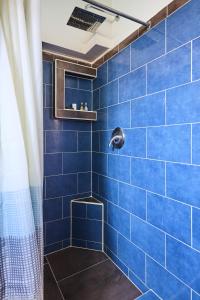 um chuveiro de azulejos azuis com uma parede de azulejos azuis em Hotel Perla de la Playa em Tamarindo