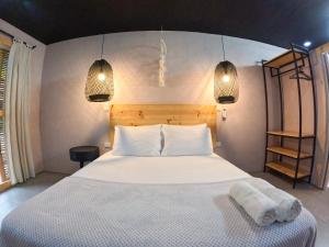 una camera da letto con un letto bianco con due asciugamani di Hotel Casa de Hadas a Minca