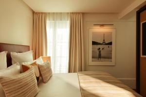 パリにあるホテル ラ ヴィラ サン ジェルマン デ プレのベッドと窓が備わるホテルルーム