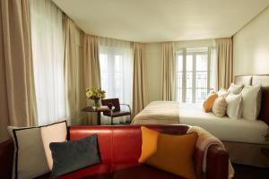 パリにあるホテル ラ ヴィラ サン ジェルマン デ プレのベッドとソファ付きのホテルルーム