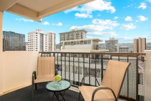 ein Balkon mit zwei Stühlen und einem Tisch mit Aussicht in der Unterkunft 2BR-2BA Close to Waikiki Beach with Free Parking! in Honolulu
