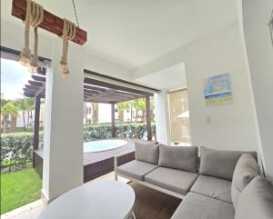 uma sala de estar com um sofá e uma piscina em Exclusivo apartamento con Jacuzzy K103 em Punta Cana