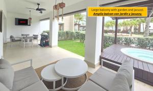 um pátio com uma mesa e cadeiras e uma piscina em Exclusivo apartamento con Jacuzzy K103 em Punta Cana